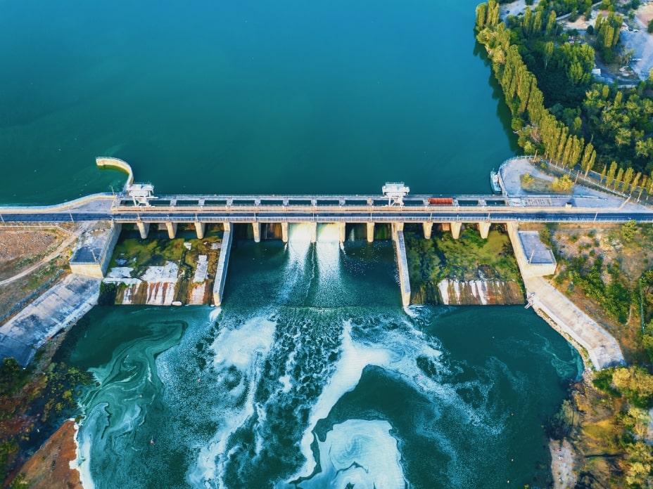 Aerial view of Dam at reservoir with flowing water, hydroelectricity power station, drone photo-min