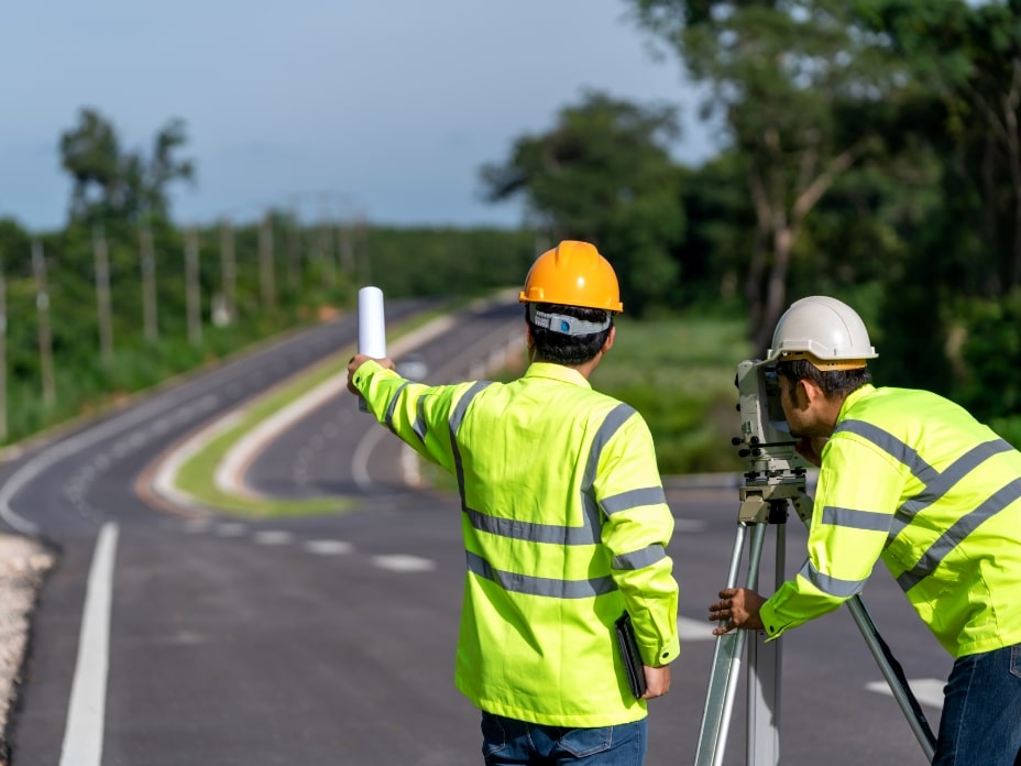 Teamwork of surveyor engineers worker making measuring with theodolite on road works. survey engineer at road construction site,-min